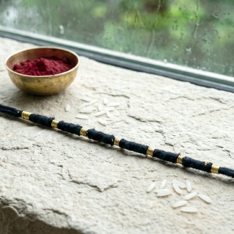 04_f444e113-16dc-4159-91c0-0854043ba2e7.jpg Rakhi � Handmade Black Thread with Gold Beads for Raksha Bandhan